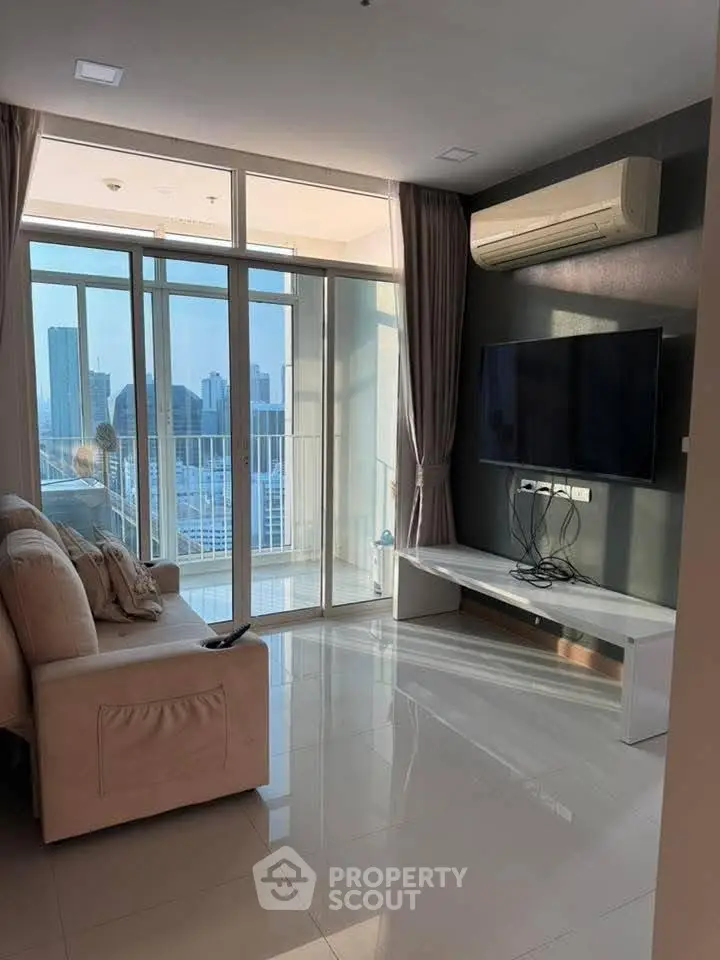 Modern living room with city view, featuring sleek furniture and large windows for natural light.