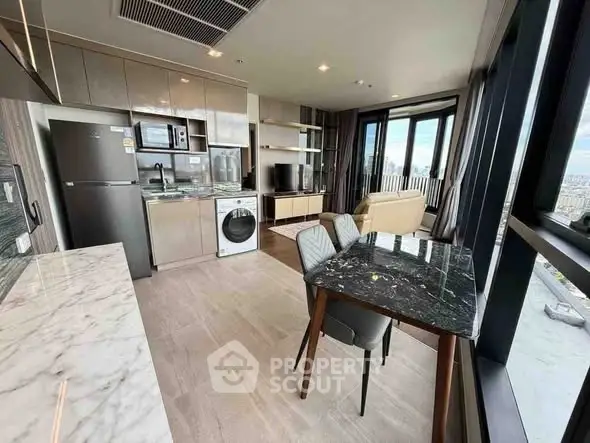 Modern open-plan kitchen and living room with city view, featuring sleek appliances and elegant decor.