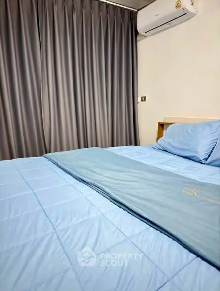 Cozy bedroom with blue bedding and air conditioning, perfect for restful nights.