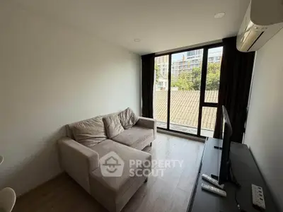 Modern living room with large window and cozy sofa in a bright apartment.