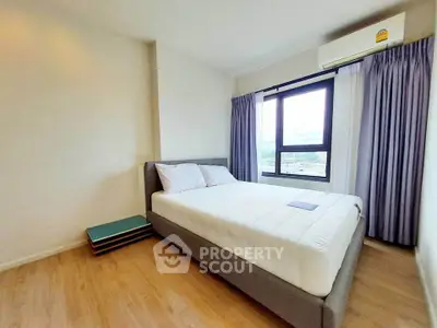 Modern bedroom with large window and minimalist decor in high-rise apartment.