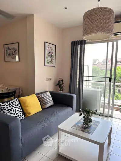 Charming living room with cozy sofa and balcony view, perfect for relaxation and entertaining.