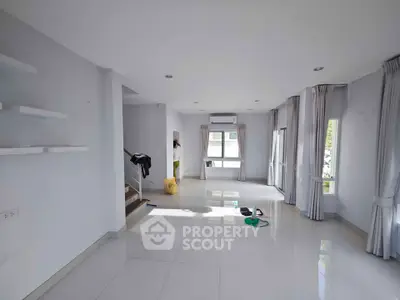 Spacious living room with large windows and modern design, perfect for natural light and comfort.