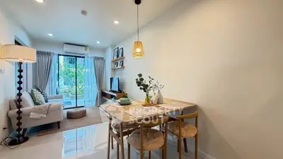 Modern living room with dining area, cozy seating, and natural light from large windows.