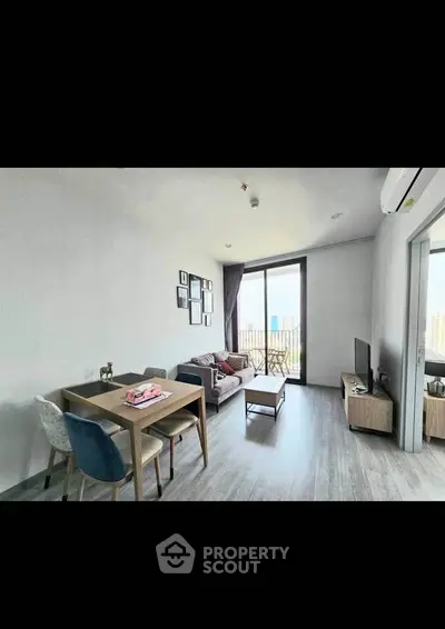 Modern living room with dining area and balcony view in a stylish apartment.