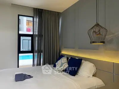 Modern bedroom with stylish lighting and pool view, featuring elegant decor and cozy ambiance.