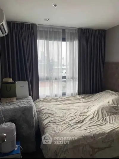 Cozy bedroom with city view, elegant curtains, and plush bedding