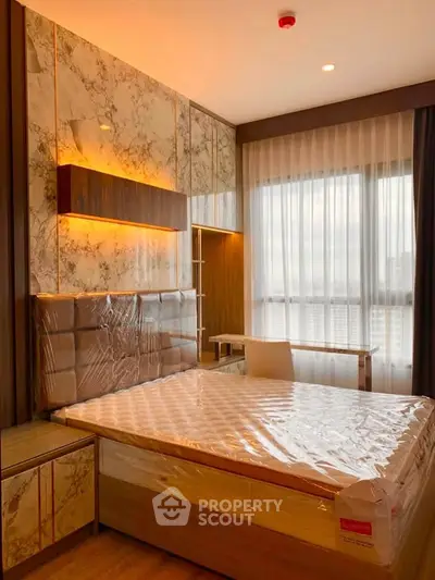 Luxurious bedroom with marble accents and large window in modern apartment