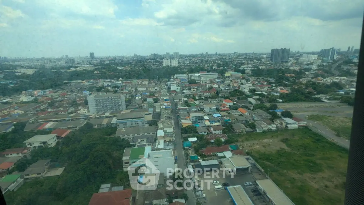 Panoramic cityscape view showcasing urban residential and commercial buildings under a cloudy sky.