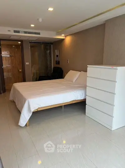 Modern bedroom with sleek design and glass-enclosed bathroom for a luxurious living experience.