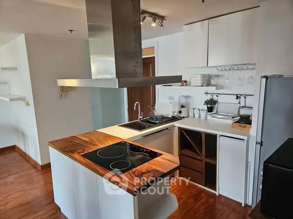 Modern kitchen with sleek design and wooden accents in a stylish apartment.