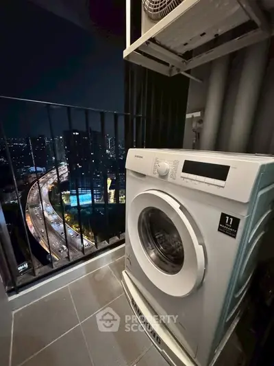High-rise balcony with washing machine and stunning city night view.