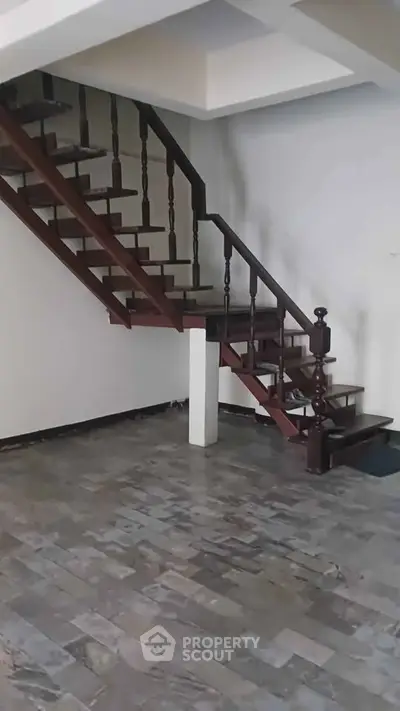 Elegant wooden staircase in a modern home with stone tile flooring