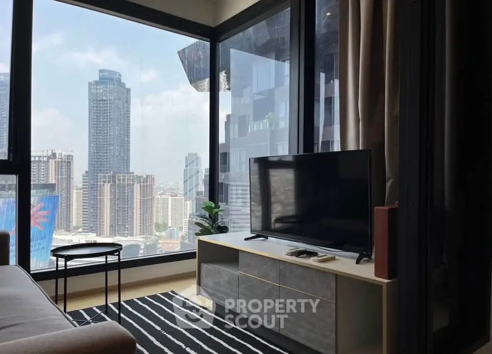Modern living room with stunning city view, featuring sleek furniture and large windows.