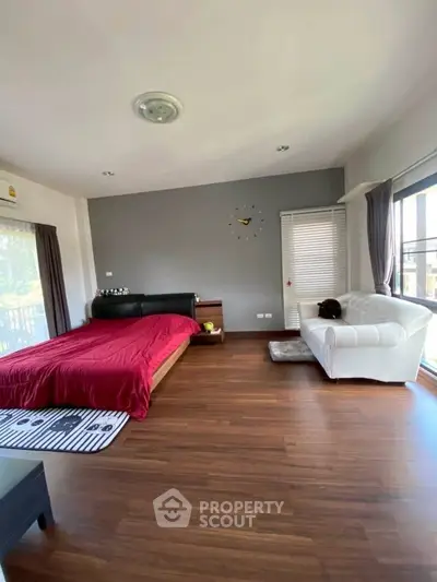 Spacious bedroom with modern decor and large windows for natural light