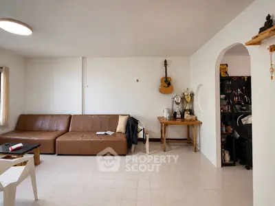 Spacious living room with modern decor and wall-mounted guitar, perfect for relaxation and entertainment.