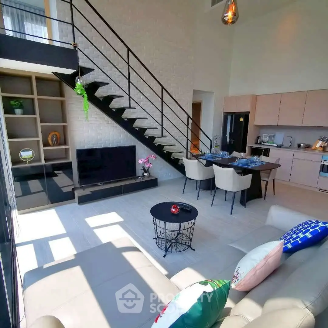 Modern loft-style living room with open kitchen and stylish staircase