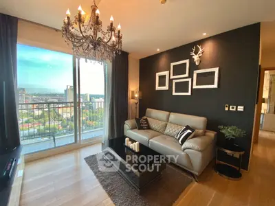 Luxurious living room with chandelier and stunning city view from balcony.
