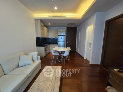 Modern open-layout living room with sleek kitchen and cozy seating area, perfect for urban living.