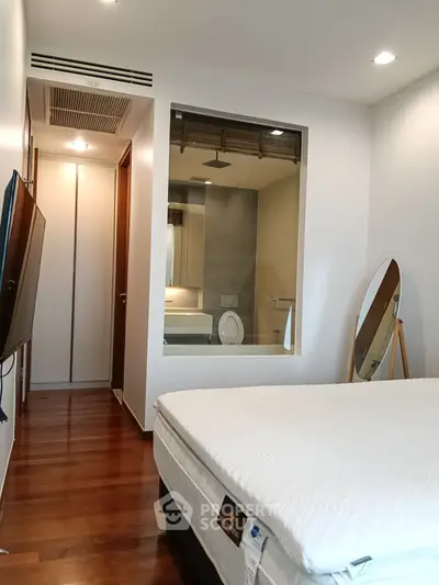 Modern bedroom with ensuite bathroom and wooden flooring