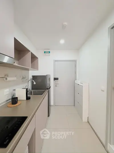 Modern kitchen with sleek cabinetry and stainless steel appliances in a compact layout.