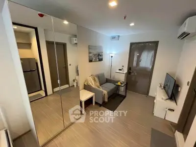 Modern living room with mirrored closet and cozy seating area in stylish apartment.