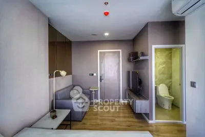 Modern studio apartment with cozy living area and compact bathroom