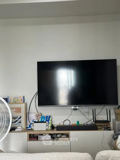 Modern living room with wall-mounted TV and entertainment setup