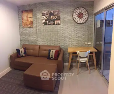 Cozy living room with brown leather sofa, stylish wall art, and modern clock.
