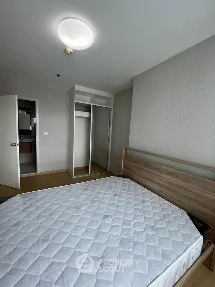 Spacious bedroom with modern design and ample closet space in a stylish apartment.