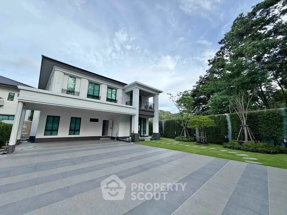 Luxurious modern two-story house with spacious driveway and lush garden, perfect for family living.