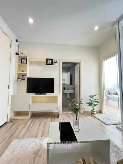 Modern living room with sleek furniture and open layout, featuring a TV and stylish decor.