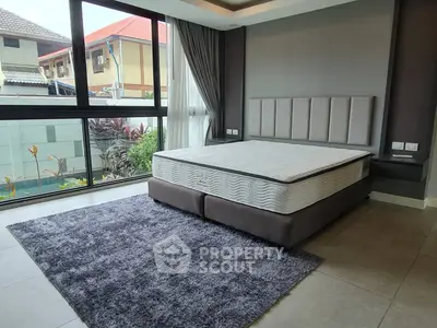 Spacious bedroom with large windows and modern decor in a stylish home.