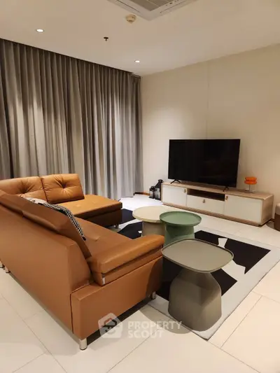Modern living room with stylish furniture and large TV, perfect for relaxation.