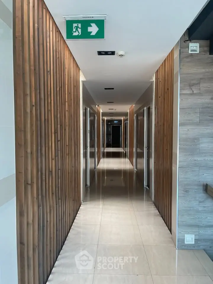 Modern hallway with wooden paneling and polished floors in a contemporary building.