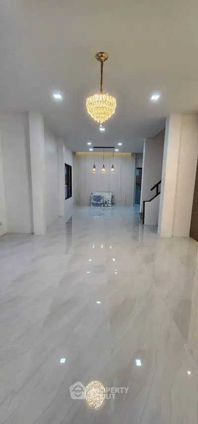 Spacious modern living room with elegant chandelier and glossy marble flooring