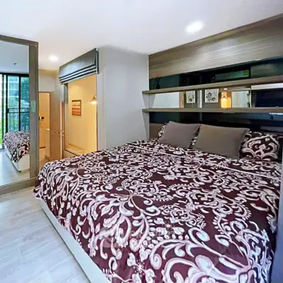 Cozy bedroom with elegant decor and large mirrored wardrobe in modern apartment.