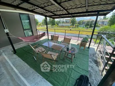 Charming balcony with outdoor seating and hammock, perfect for relaxation and enjoying scenic views.