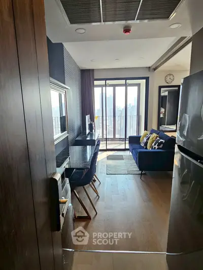 Modern living room with city view, stylish decor, and open layout in high-rise apartment.