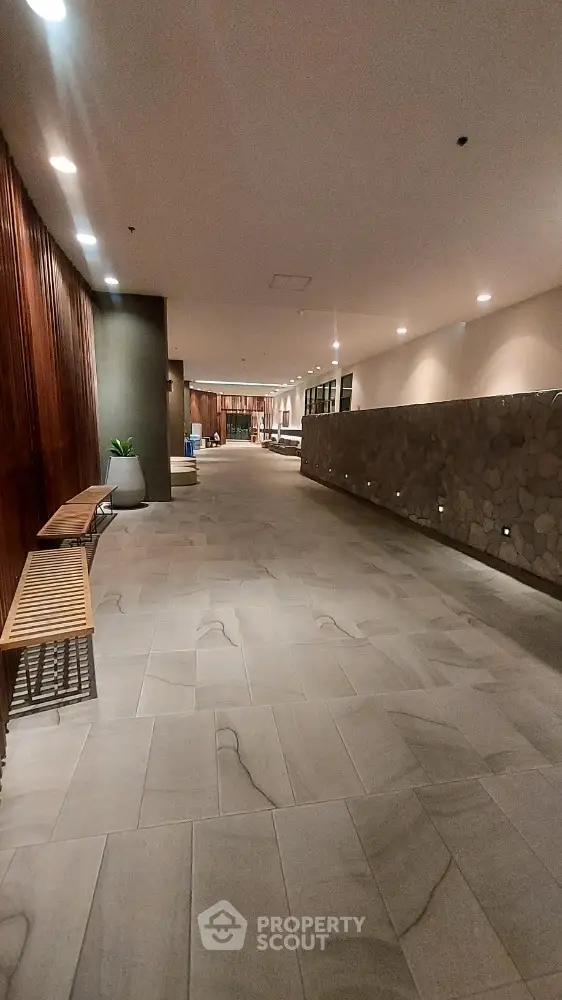 Spacious modern building entrance with elegant stone wall and seating area