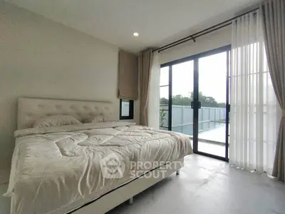 Spacious bedroom with large windows and modern decor, offering ample natural light and serene ambiance.