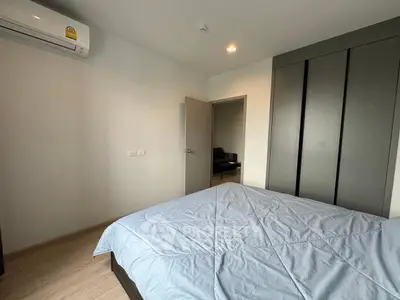 Modern bedroom with sleek wardrobe and air conditioning in a stylish apartment.