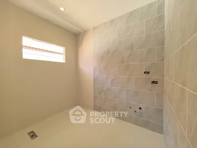 Spacious modern bathroom with elegant tile design and natural light.