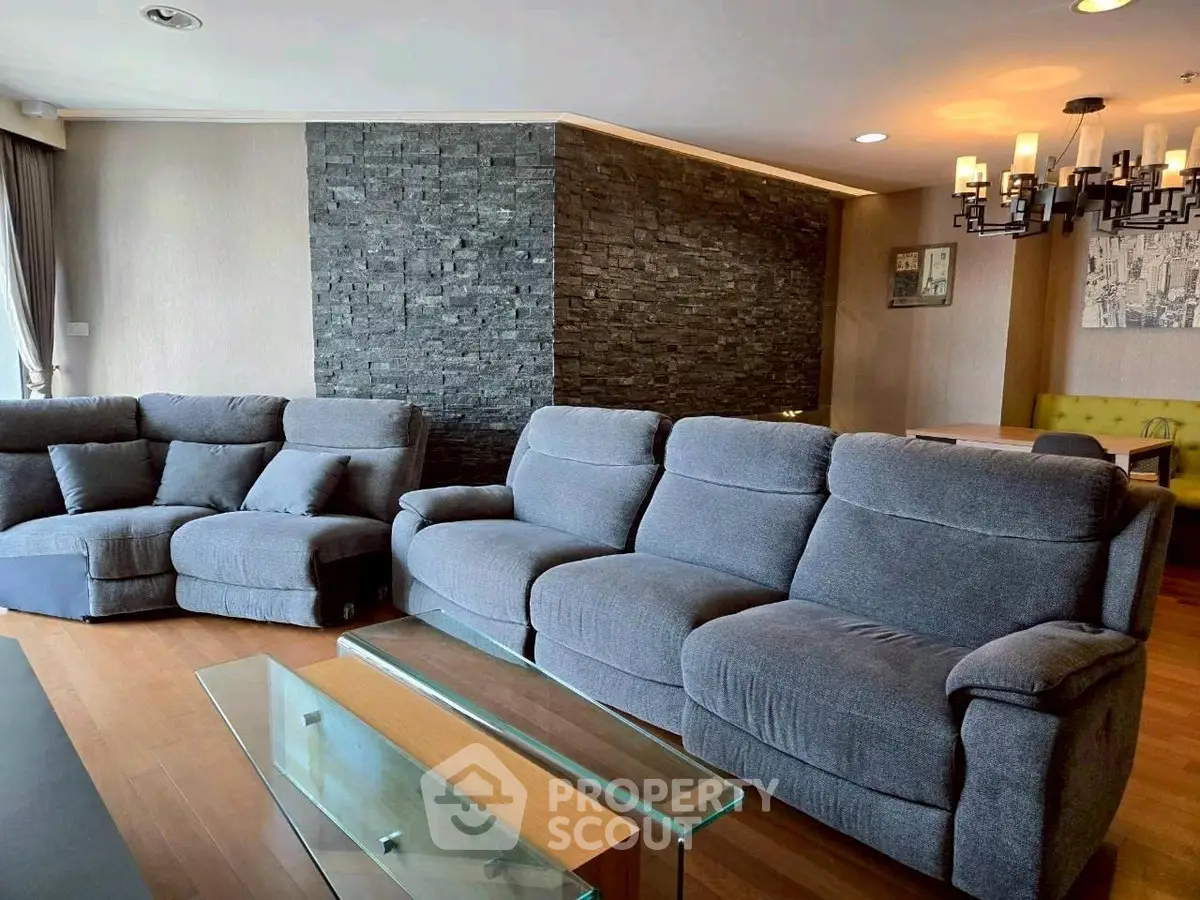 Spacious living room with modern gray sofas and elegant stone accent wall