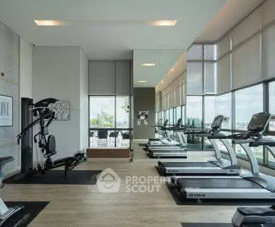 Modern gym with treadmills and exercise equipment in a luxury apartment building.