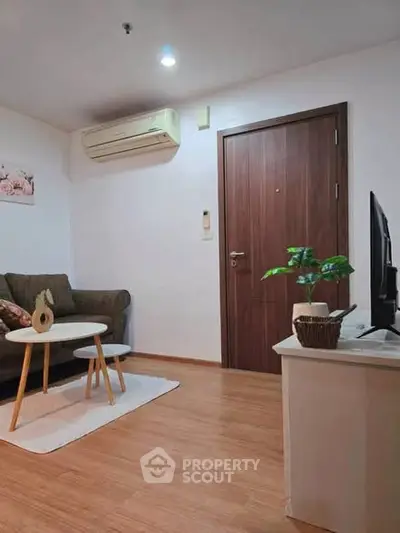 Cozy living room with modern decor and air conditioning, perfect for relaxation.