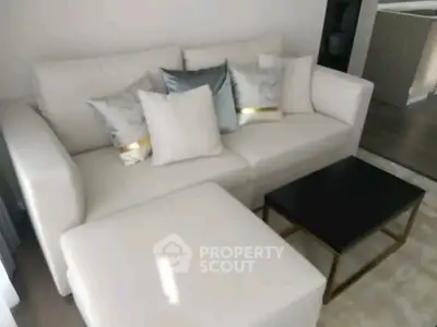 Elegant living room with plush white sofa and modern coffee table, perfect for relaxation.