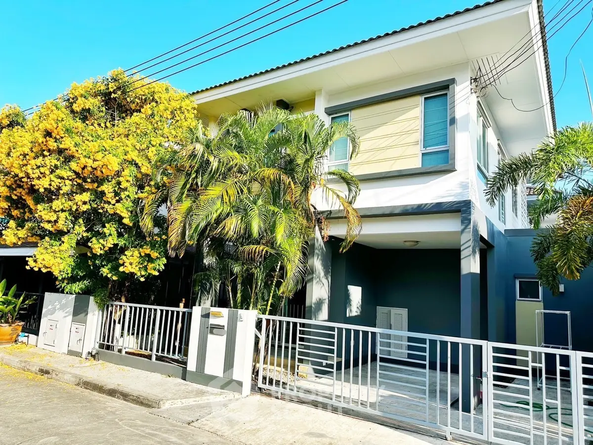 Charming two-story house with lush greenery and modern facade