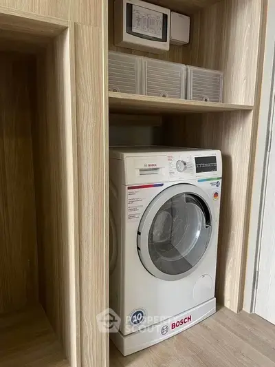 Modern Bosch washing machine in sleek wooden laundry nook, perfect for efficient urban living.