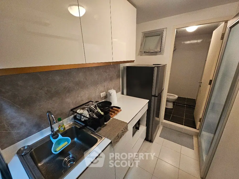 Compact kitchen with modern appliances and adjacent bathroom